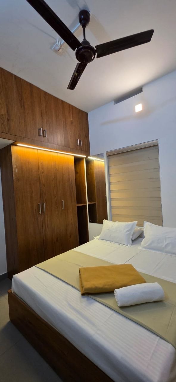 Room with a full wooden wardrobe and soft cove lighting