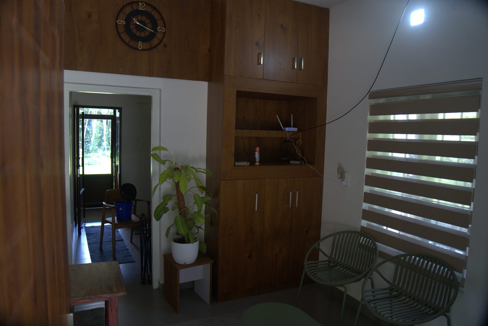 Sitting area beside a wooden wardrobe and a blinded window
