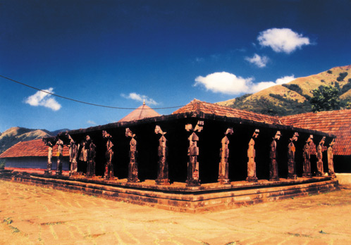 Thirunelly Temple's sculpted pillared hall against the Brahmagiri hills
