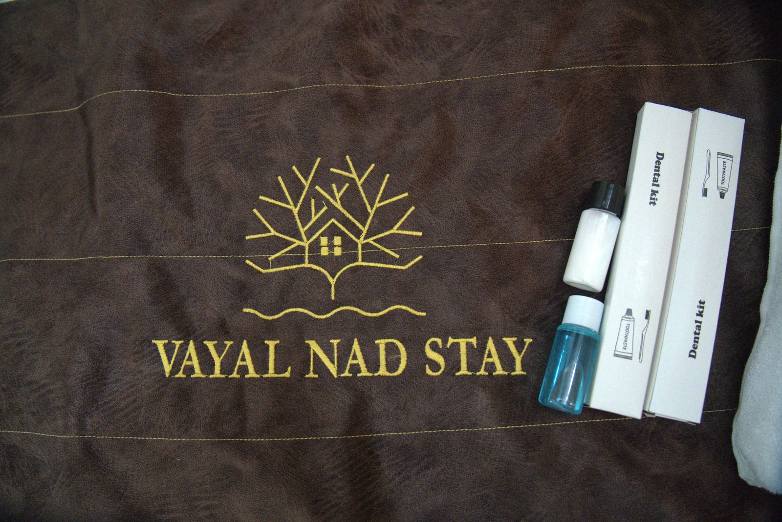 Branded bed runner with the Vayal Nad Stay logo and a small amenity kit