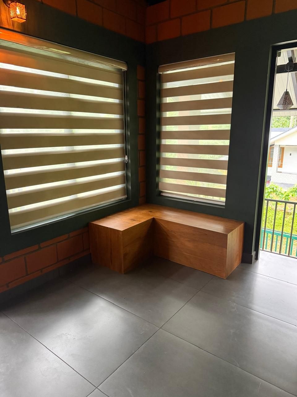 Solid wood bench in a corner between two blinded windows